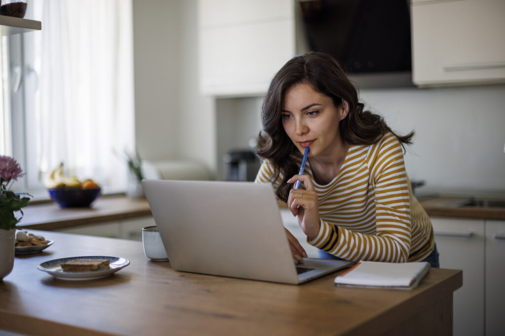 a young woman using her laptop while working from home