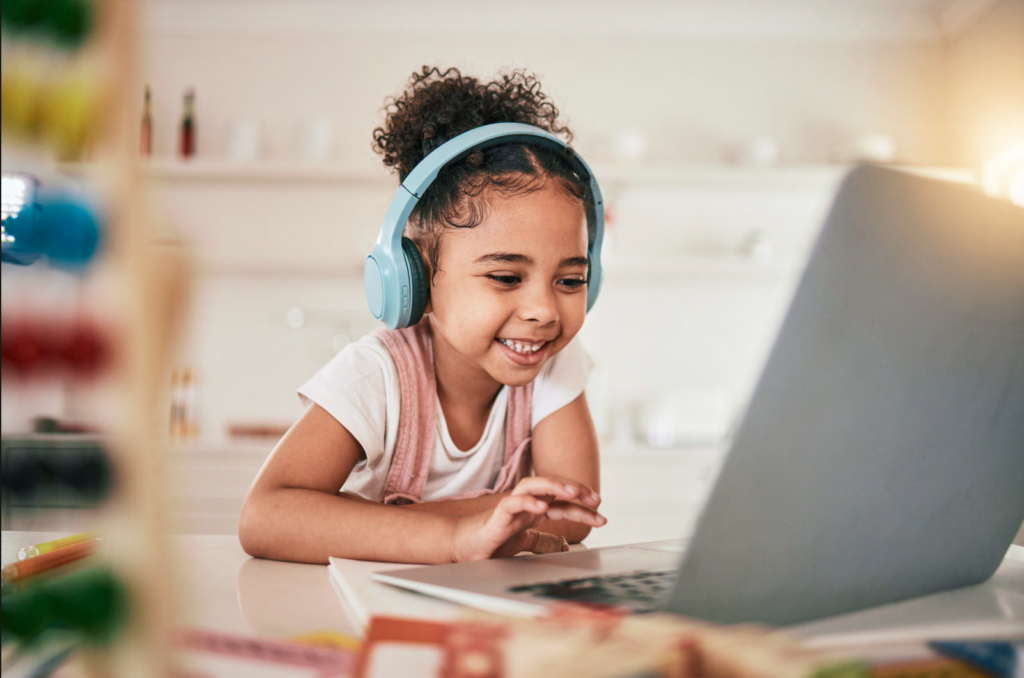 a young girl with headphones on a computer