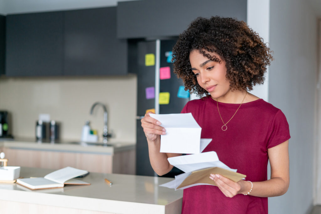 a woman in her kitchen reading her mail