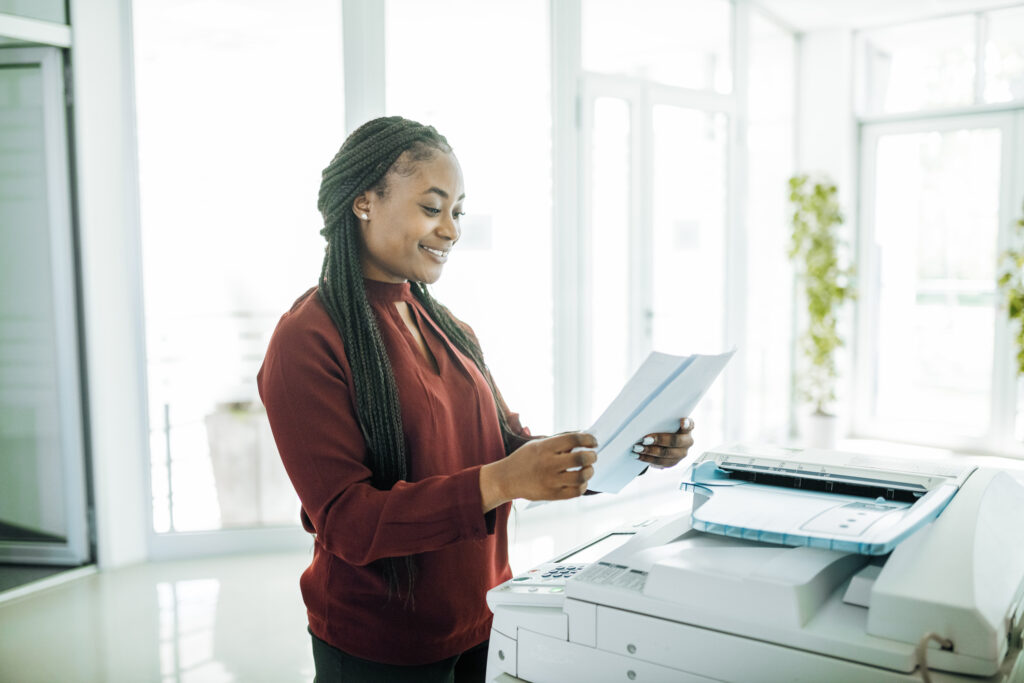 a businesswoman in her office, using copy paper