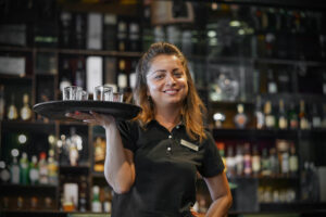 a waitress carrying a whiskey glass